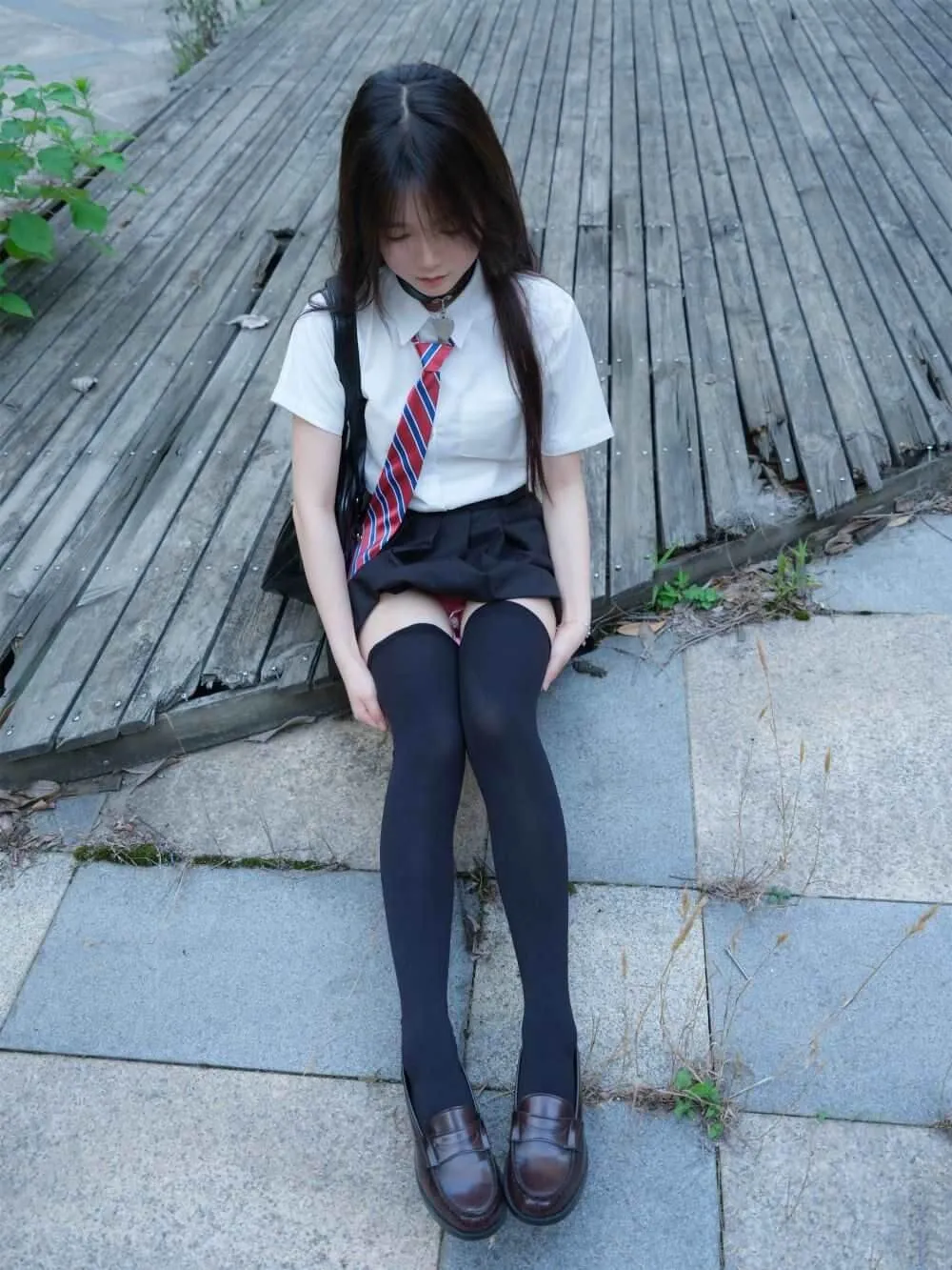 小恩穿着黑色丝袜与校服,坐在户外木地板上,展现甜美的校园风与自然氛围