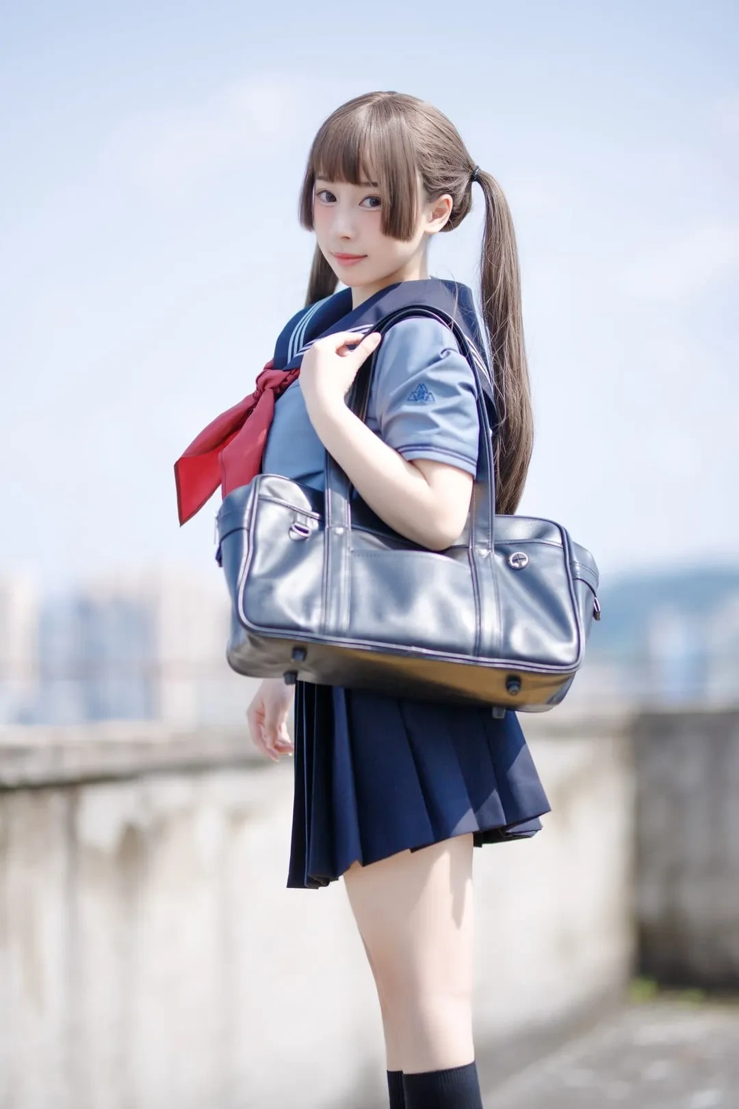 户外蓝天背景下侧身站立的制服人物，双马尾发型搭配手提包