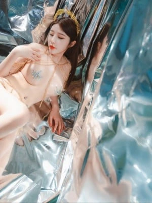 银色反光背景中穿轻薄服饰侧卧姿态