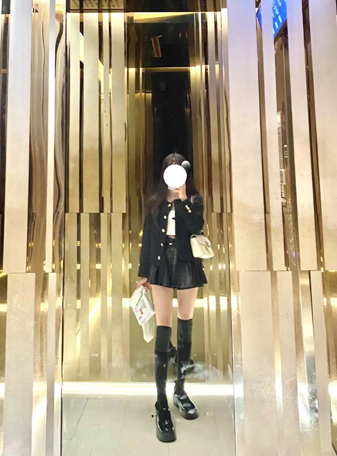 唐伯虎商场金色镜面空间全身自拍，黑色小香风外套搭配皮质短裙与黑色长靴，都市轻熟风格造型展示