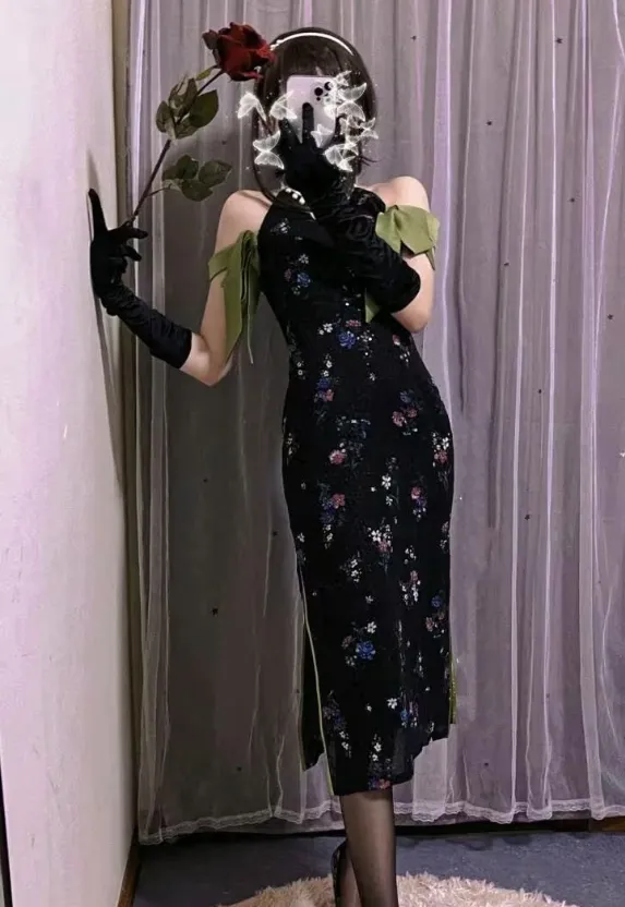 小青茗黑色花纹旗袍造型，绿色肩带装饰，黑色长手套，手持红色玫瑰站姿拍摄，室内纱帘背景