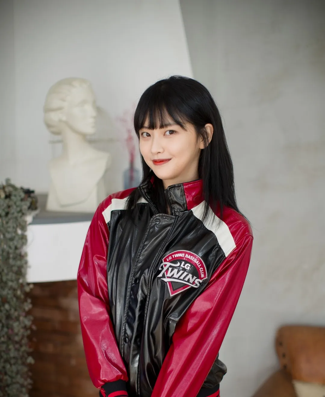 LEEHEE EXPRESS写真作品，模特身穿LG Twins红黑配色棒球夹克，室内石膏头像背景站姿，韩系街头风格展示