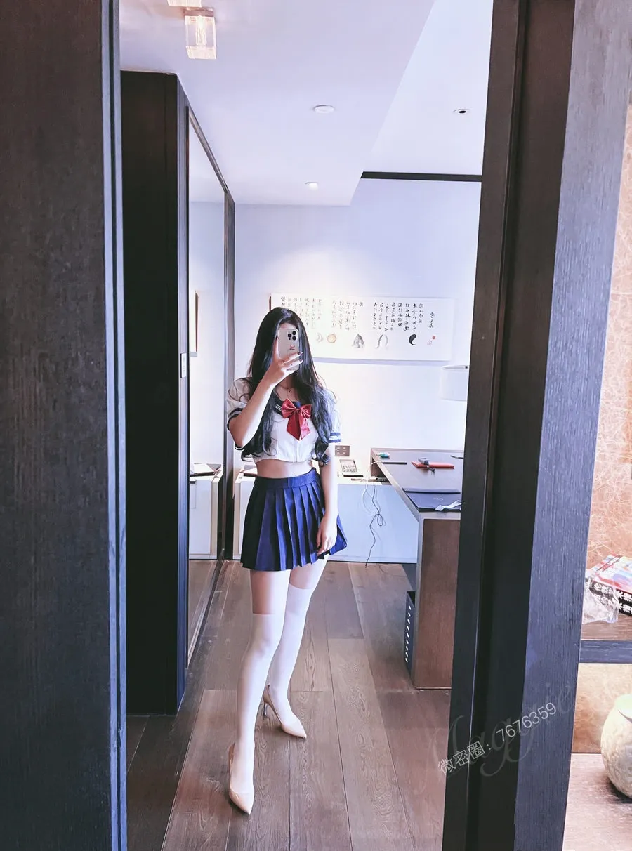 安乔乔在室内对镜自拍,穿短款上衣百褶裙和白色长袜的全身造型