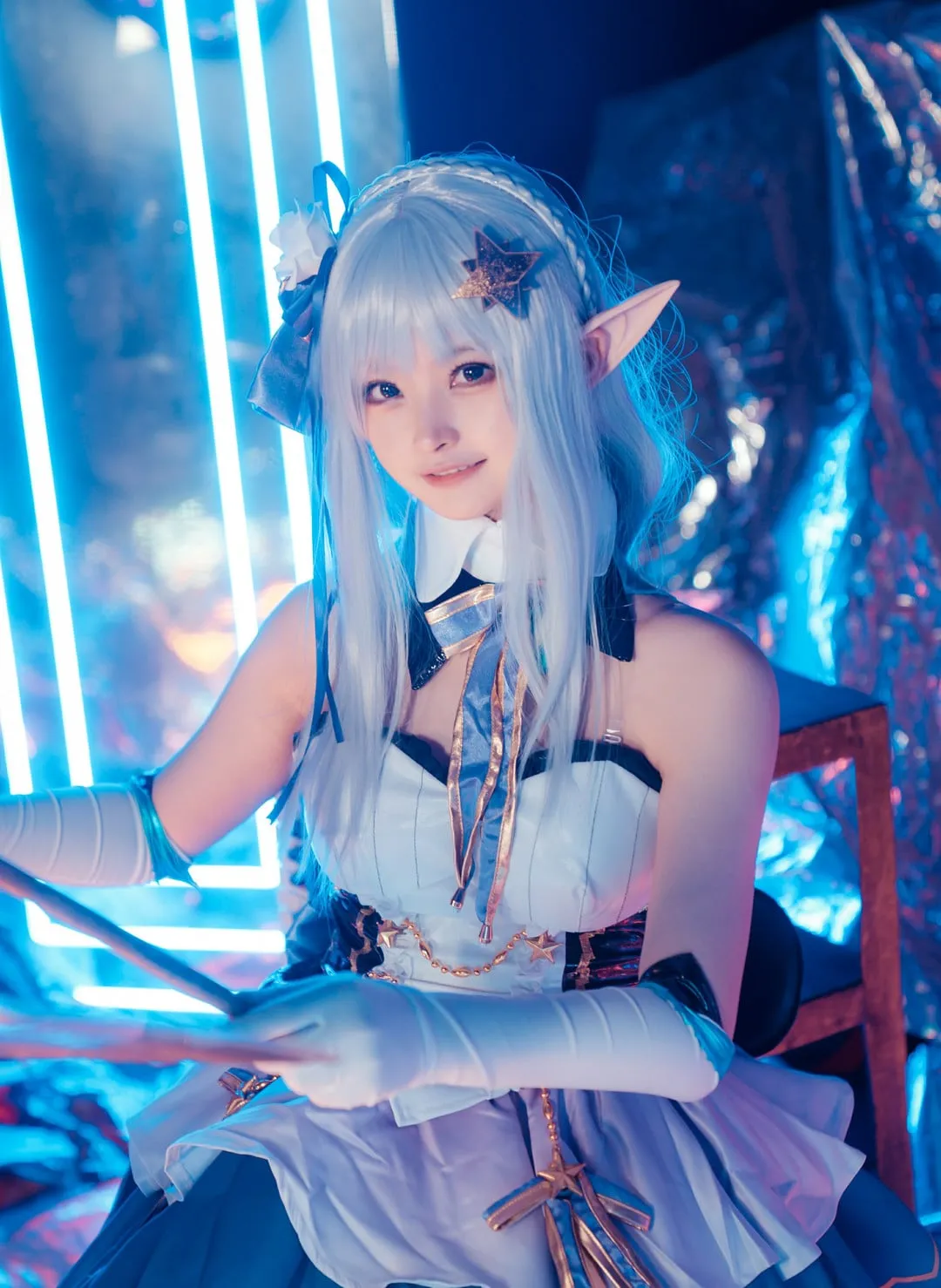 白莉爱吃巧克力在蓝色霓虹场景蓝白角色服坐姿出镜，发饰与服装细节清晰