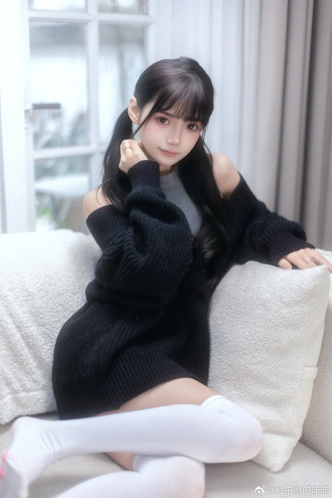 会拍照的咔咔黑色毛衣坐在白色沙发上的室内写真图