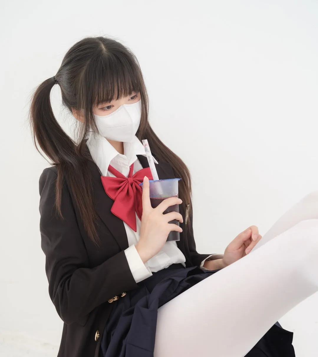 紧急企划双马尾制服写真，黑色制服外套配红色蝴蝶结和白丝袜，人物戴白色口罩手持饮料，纯白背景展示