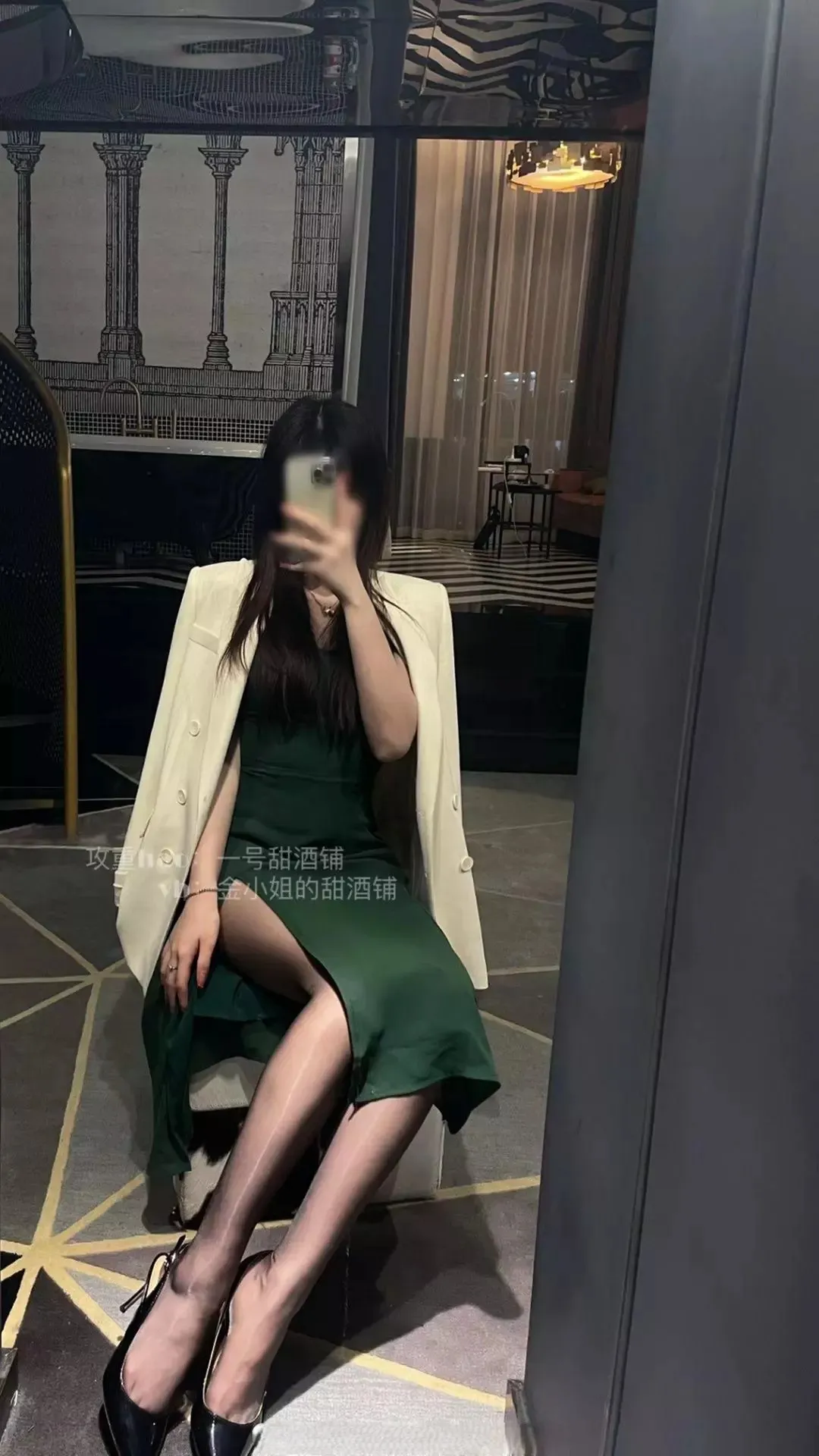 金克丝酒店落地镜全身自拍,深绿色吊带鱼尾裙搭配米白色双排扣西装外搭,黑色细跟高跟鞋,侧坐椅上,精致御姐风格展示