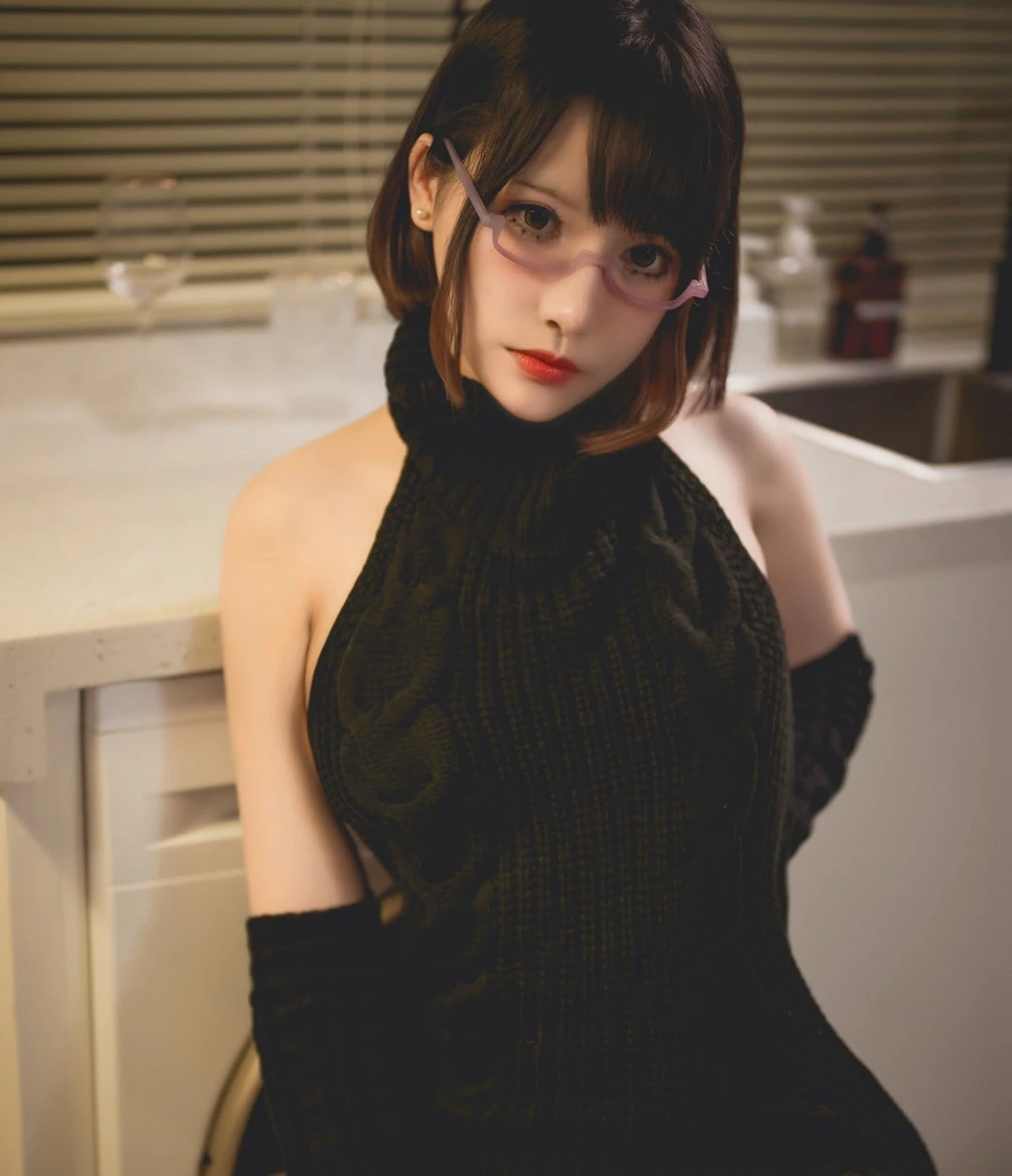你十七鸽黑色礼服坐在室内台面旁的写真图