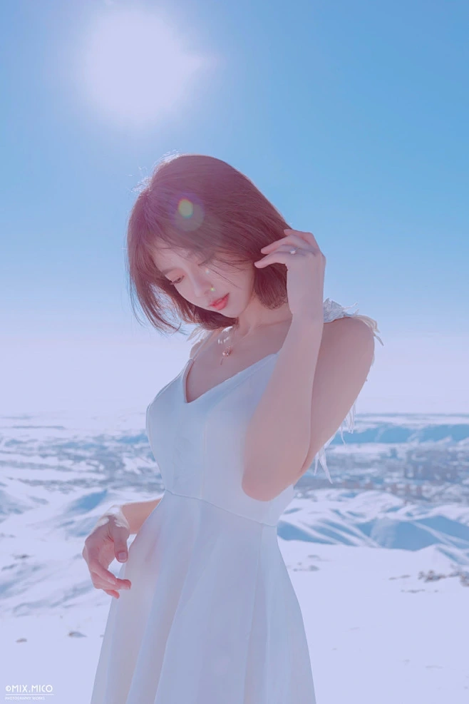 摄影师mix作品中短发模特在雪地站立,穿白色吊带裙并抬手扶发 写真