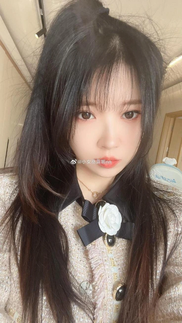 小女巫露娜在室内暖光环境黑发自拍近景出镜，蝴蝶结领饰与外套纹理清晰