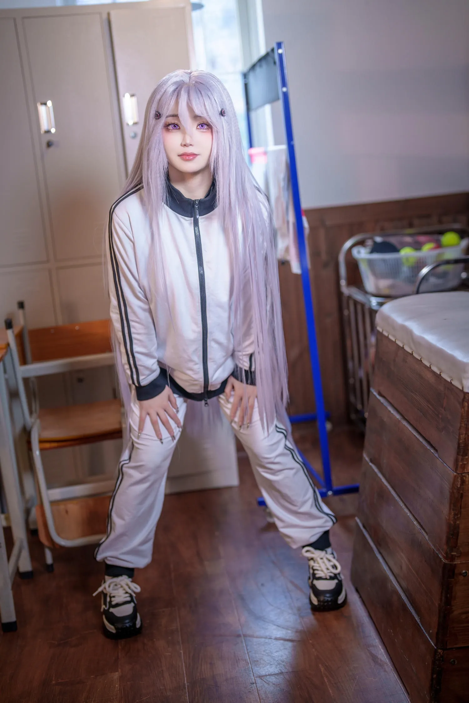 一只毛毛帽穿浅色运动套装站在室内的全身写真