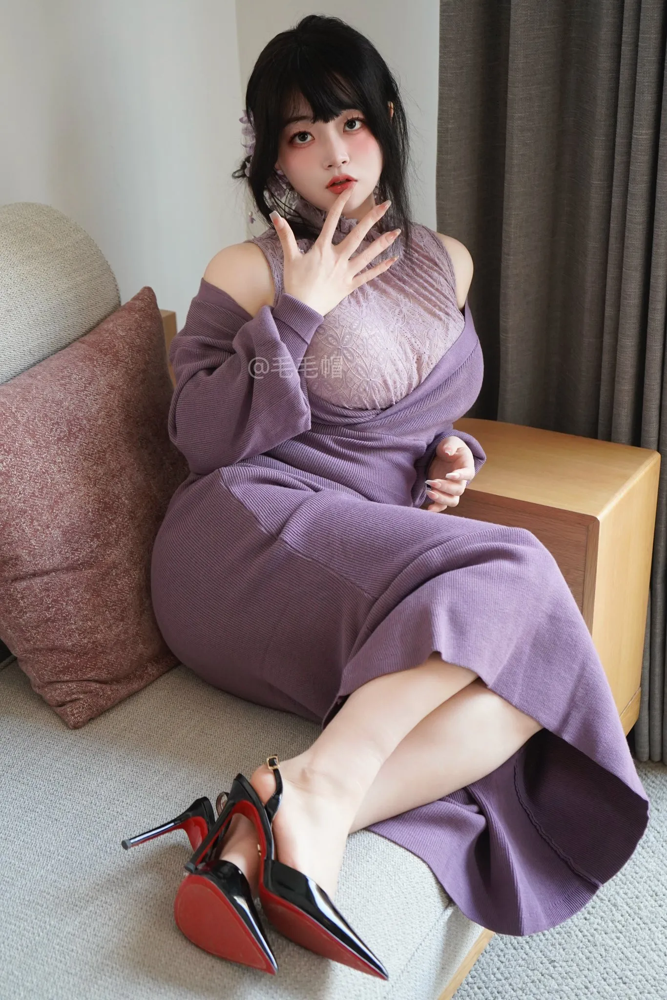 一只毛毛帽穿紫色长裙坐在沙发上的室内写真