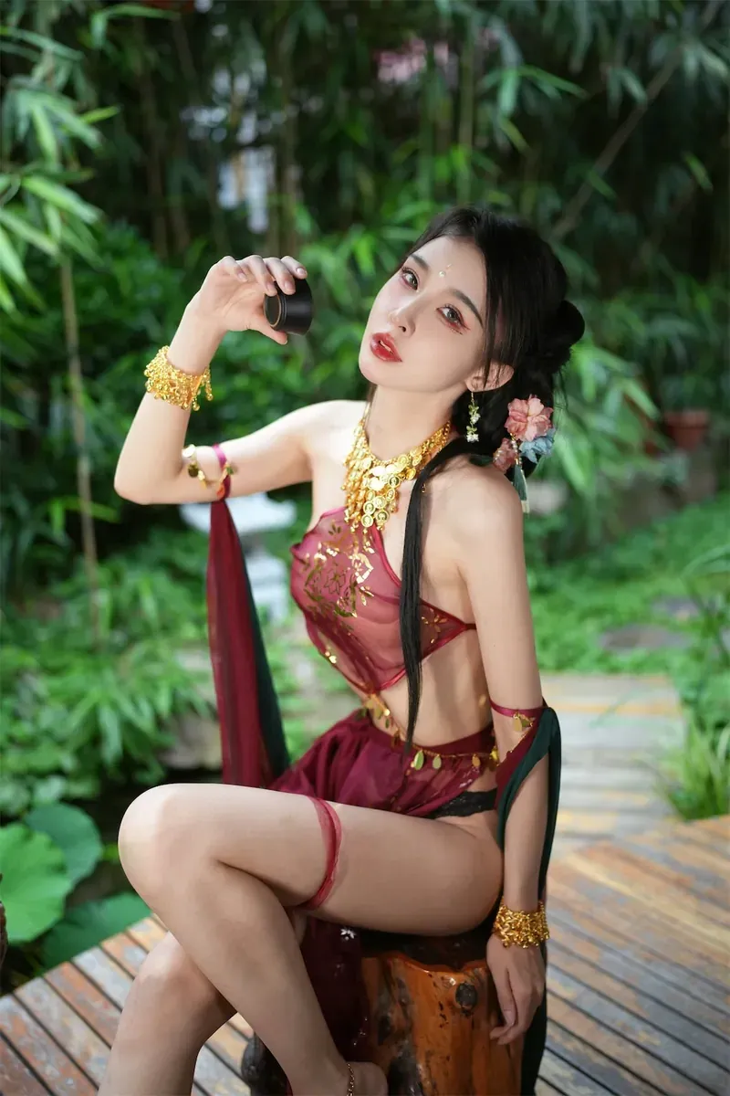 余多多dudu酒红古风服饰坐在庭院木凳上的写真图