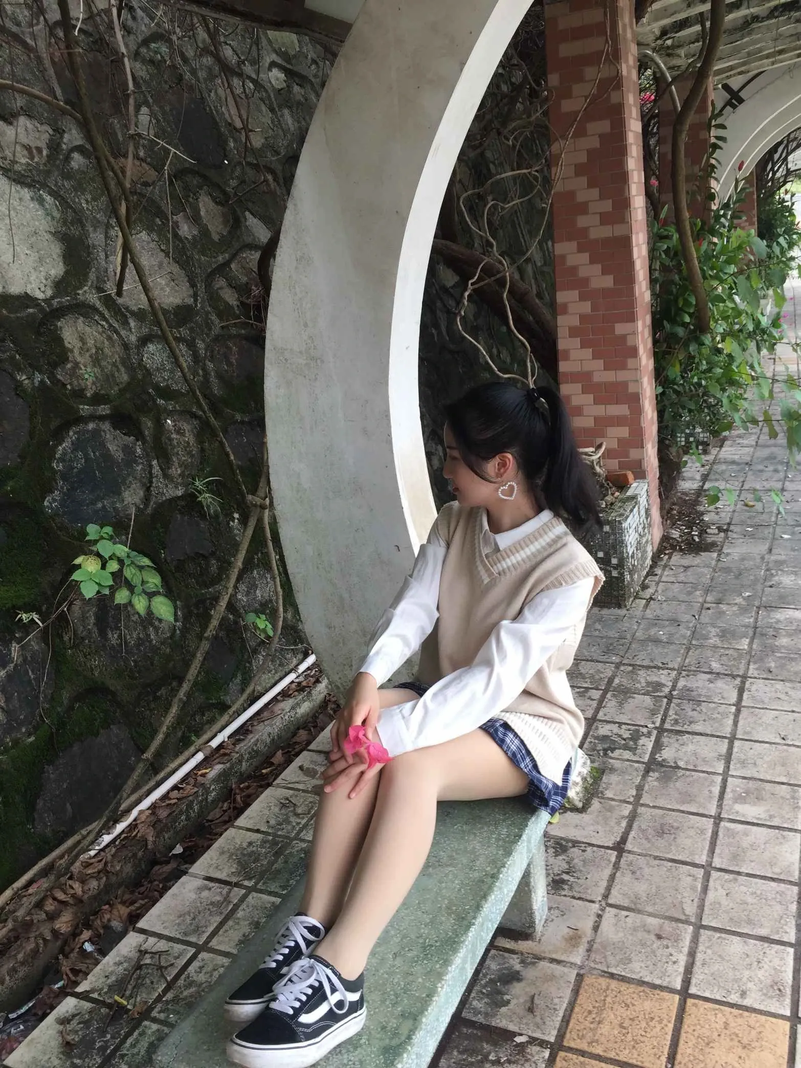 最爱帆布鞋穿白色外套和短裙坐在户外长椅上的写真