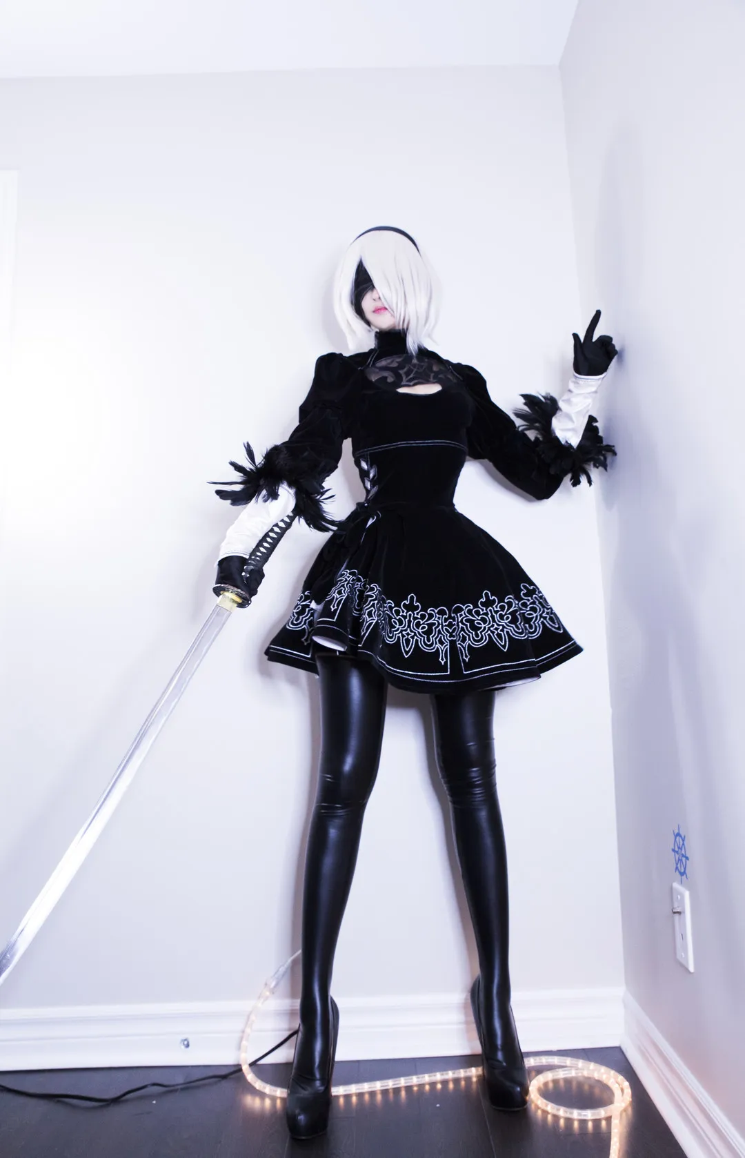 MisswarmJ白发黑色兜帽造型搭配黑色长袜站在白墙前