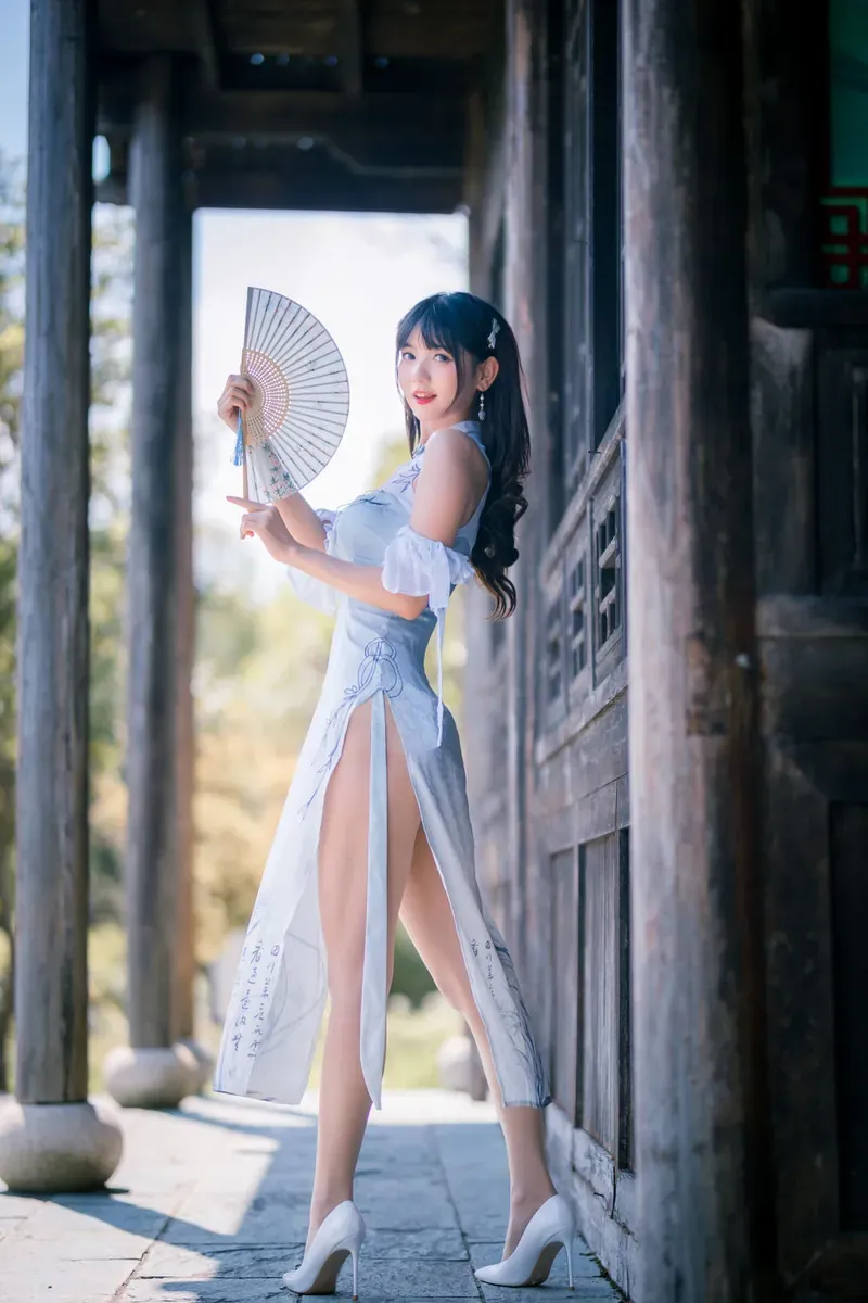 PAKI酱白色开衩旗袍手持折扇站在木质廊道旁