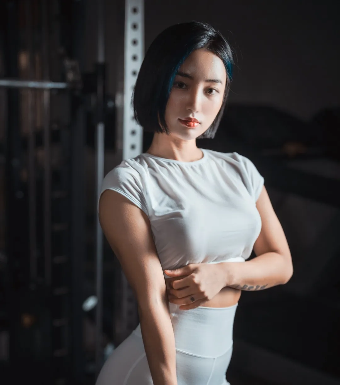 BootyQueen 黑色短发白色短袖上衣浅色高腰裤站在暗色室内