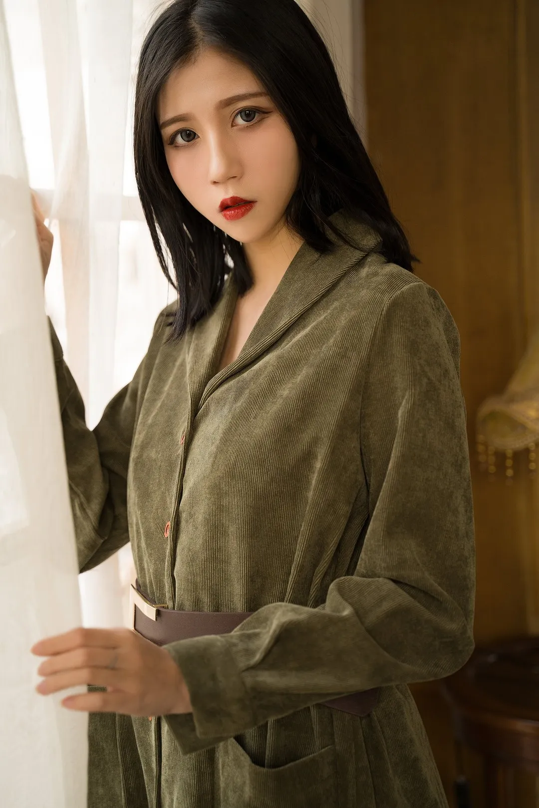 Cazi姬纪黑色短发橄榄绿色长袖服饰站在白色窗帘旁
