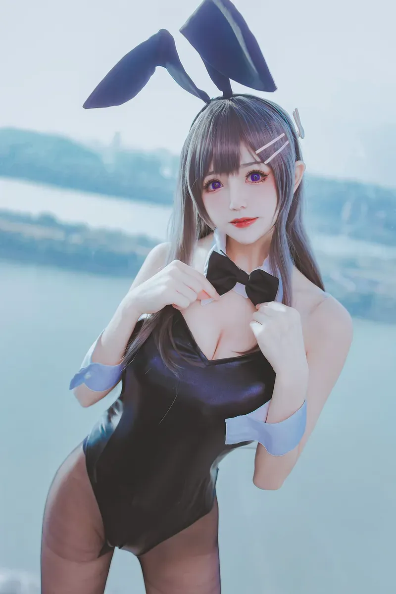coser衣衣灰紫色长发黑色兔耳黑色兔女郎服饰站在明亮水域背景前