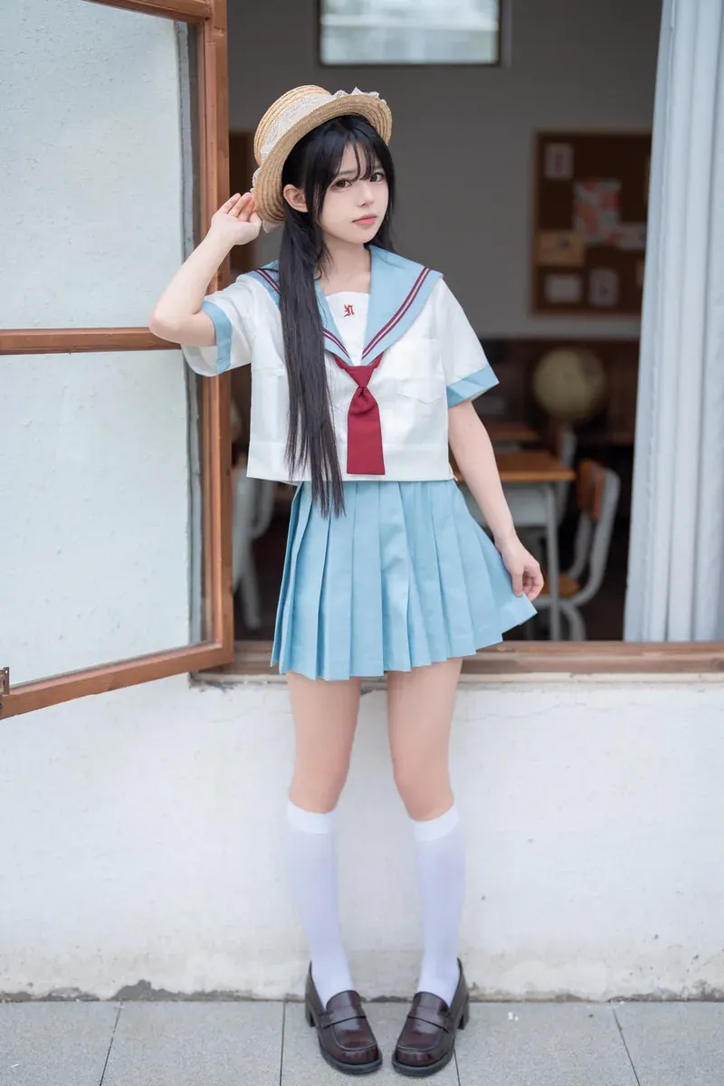 rua阮阮穿蓝色校服裙站在户外走廊前的全身照片