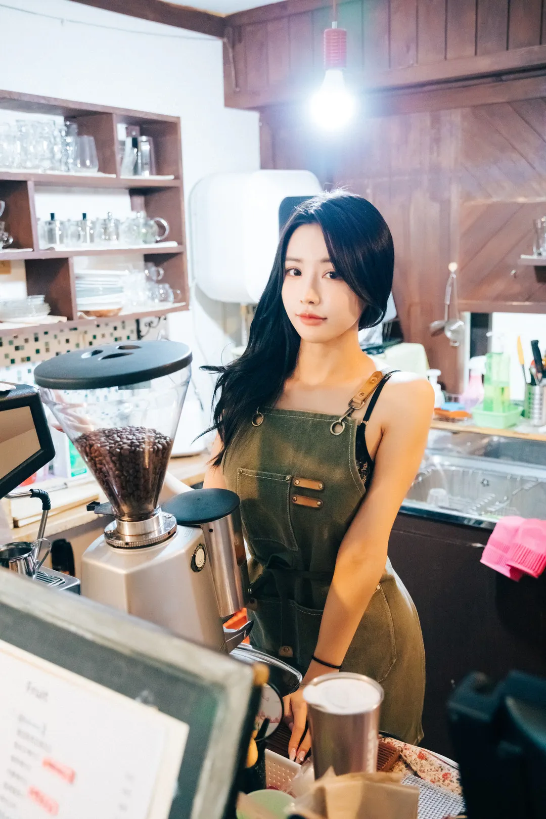 YeonYu(연유)长发穿绿色围裙站在咖啡吧台与磨豆机旁