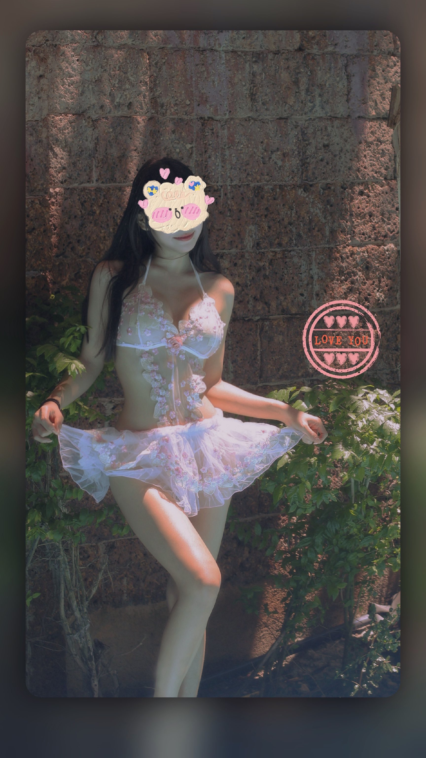 咪妮MiNimmm2006穿浅色薄纱裙装站在石墙和绿植前