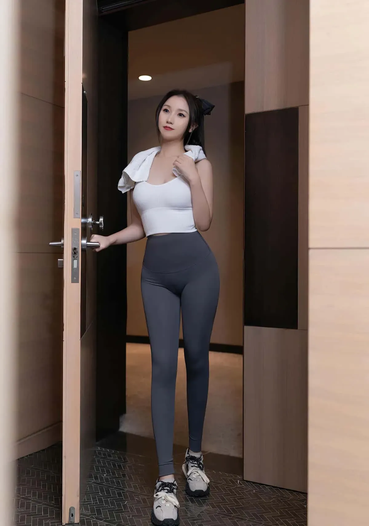 杏子Yada白色上衣灰色紧身运动裤站在门边的写真