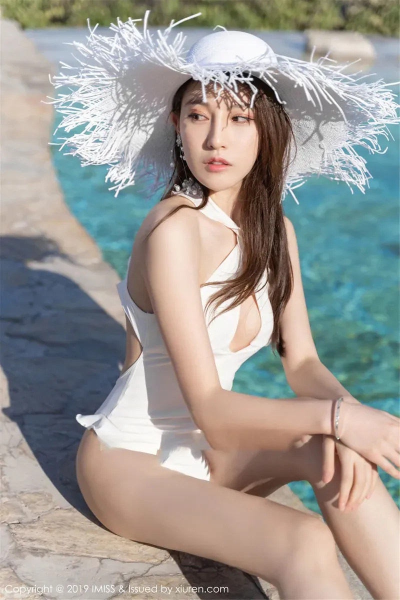 51酱戴白色宽檐帽穿白色服装坐在池边