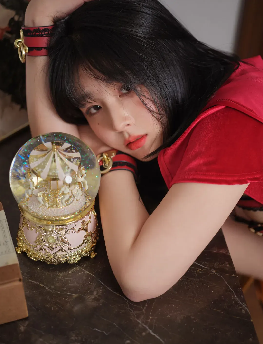 ARTGRAVIA 黑发模特穿红色服饰趴在桌边靠近水晶球