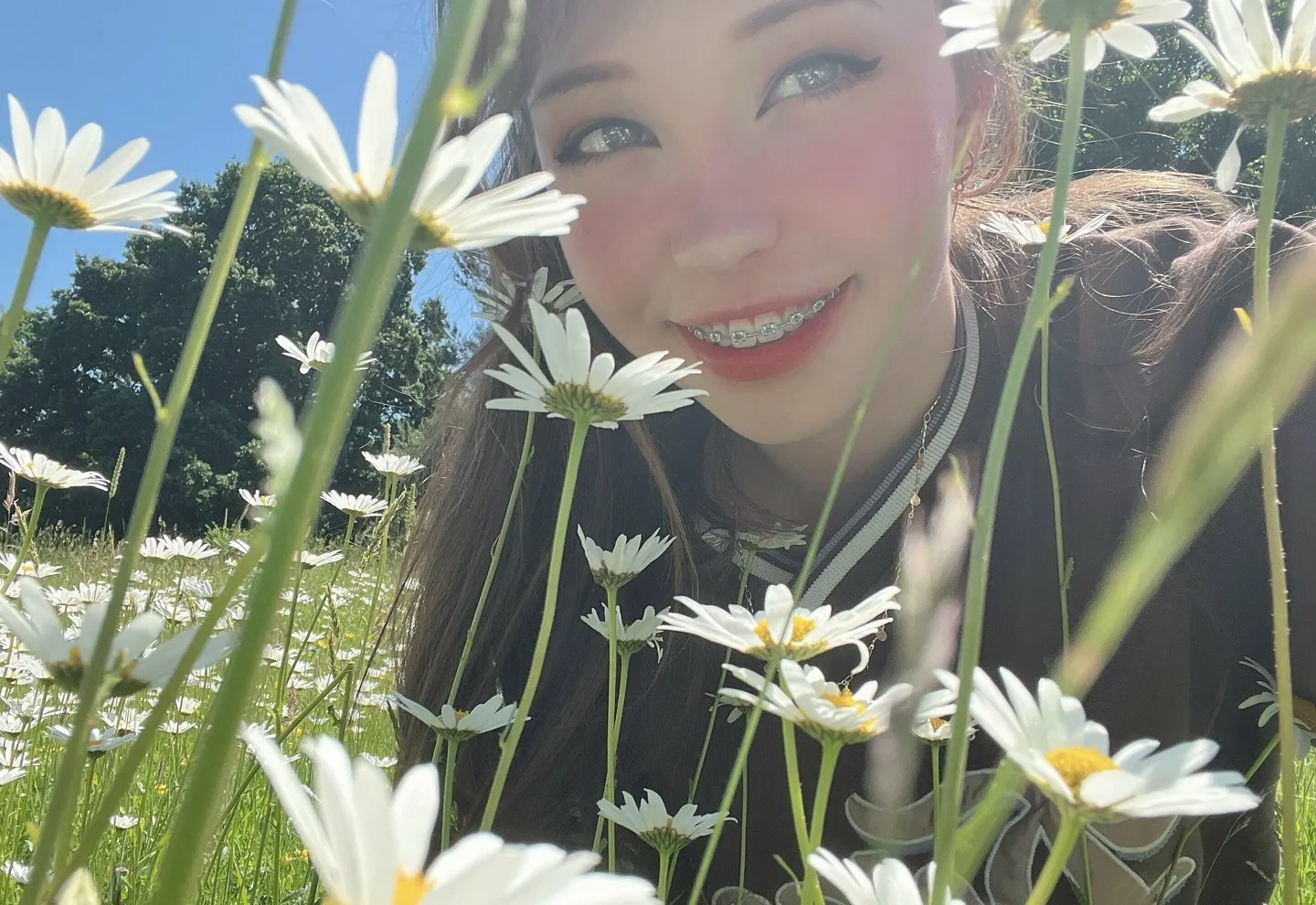 BelleDelphine在白色雏菊花丛中靠近镜头微笑自拍