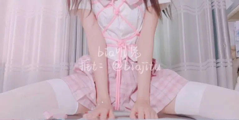软甜糯米糍穿粉白服装和格纹短裙坐在室内窗帘前