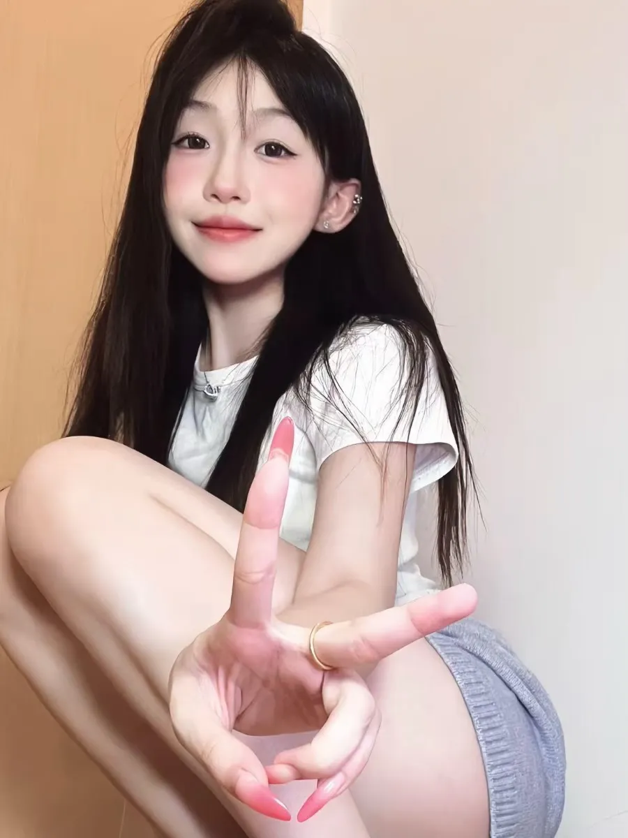 抖音别拔虎牙黑色长发穿白色上衣和灰色短裤，近景对镜头比手势