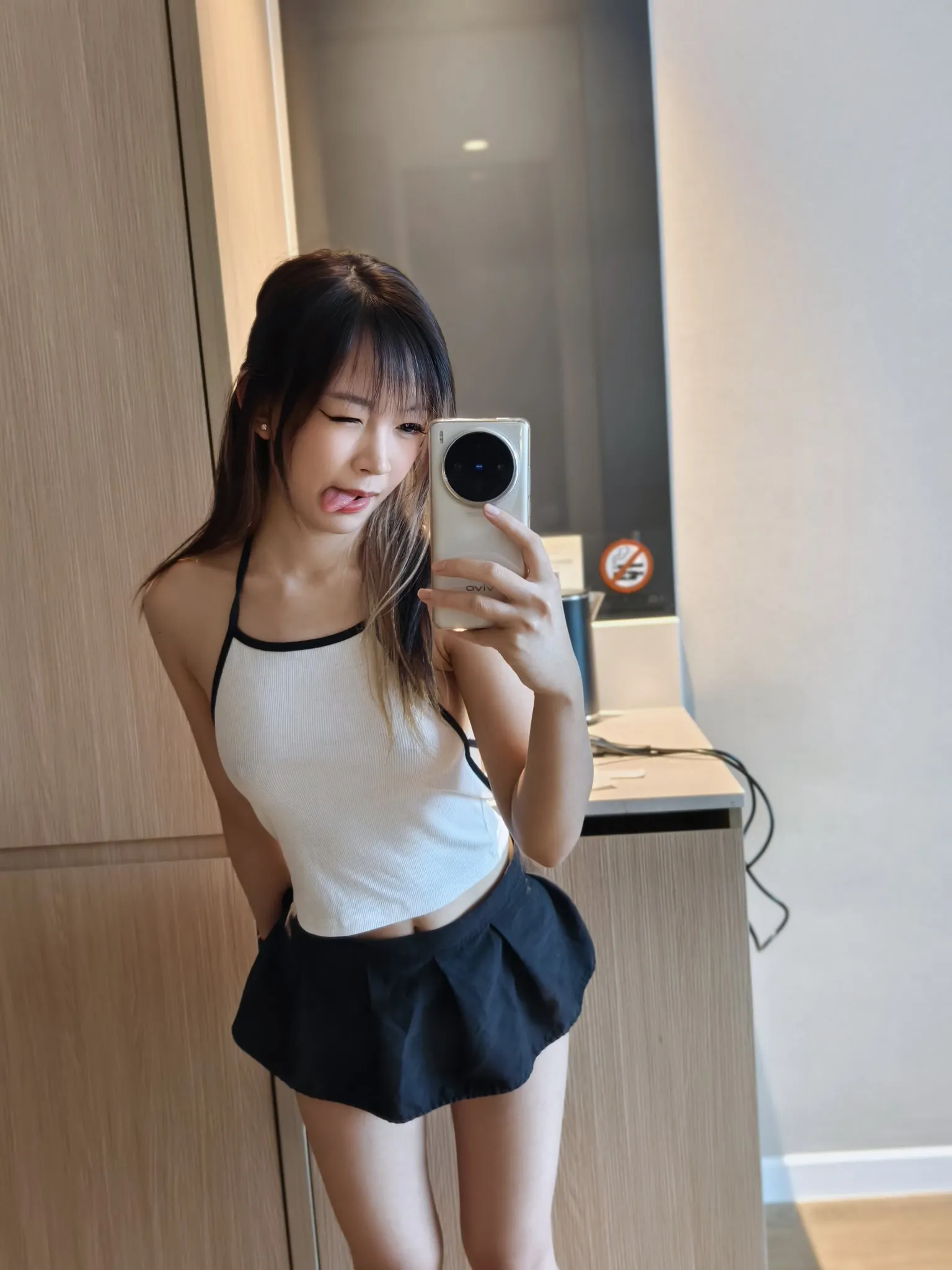 Jayinne长发刘海穿白色黑边背心和黑色短裙拿手机自拍