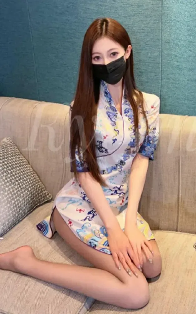 黎允熙baby穿蓝白印花旗袍戴黑色口罩坐在沙发上
