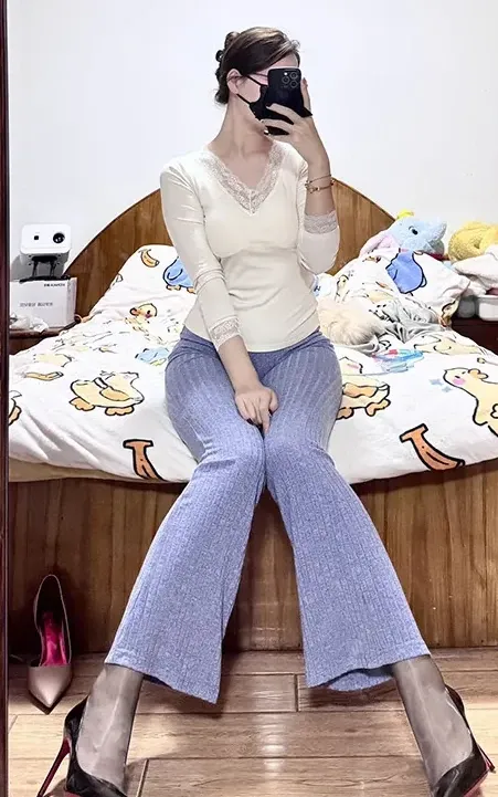 余珠珠浅色针织上衣淡紫色长裤床边坐姿写真