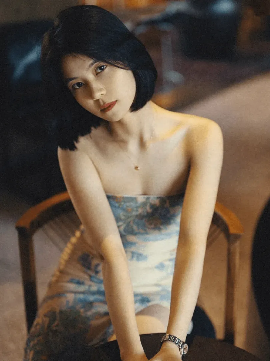 孬子妹短发坐姿写真,蓝白服装与室内暖色背景