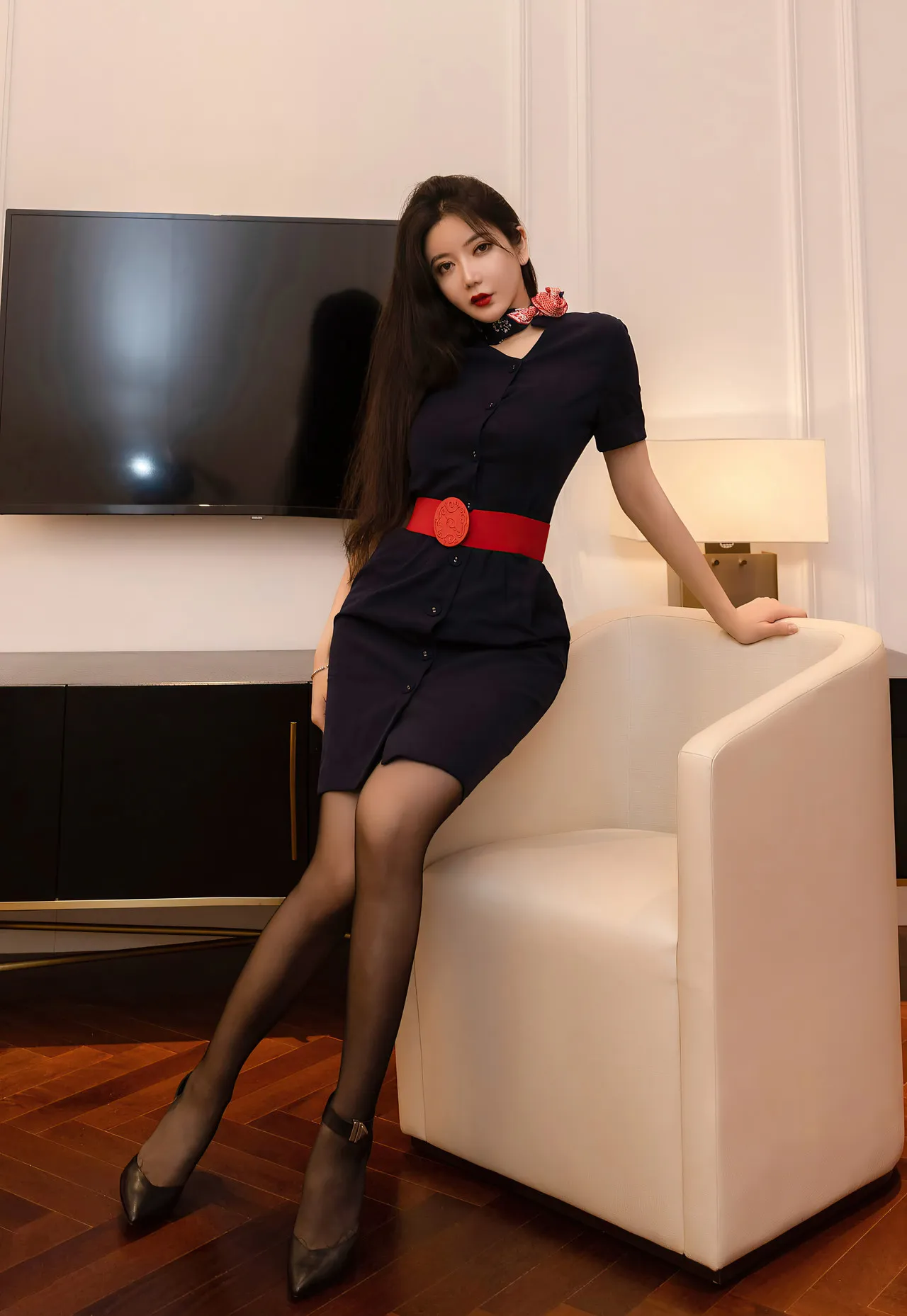 心妍小公主穿深色连衣裙坐在白色沙发旁的室内写真