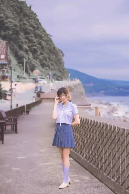少萝没人爱穿蓝色制服裙站在海边步道的写真