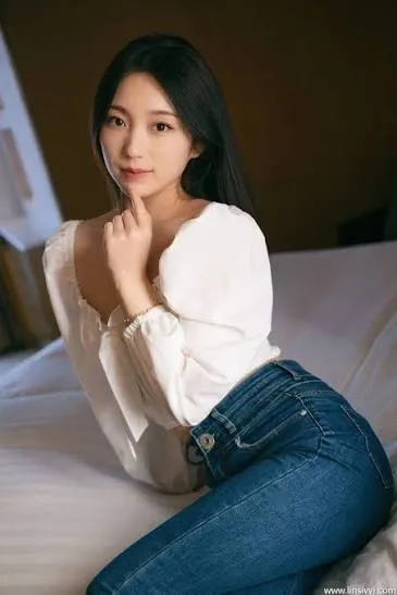 希威社甜甜穿白色上衣和蓝色牛仔裤趴在床上的写真