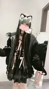 一只可爱简戴黑色猫耳头饰穿黑色外套和短裙站在室内门边